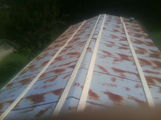 Rusted metal roof panels with new wood purlins before replacement — Storm Damage Roof Repair in Ricketts by Roofing Brothers