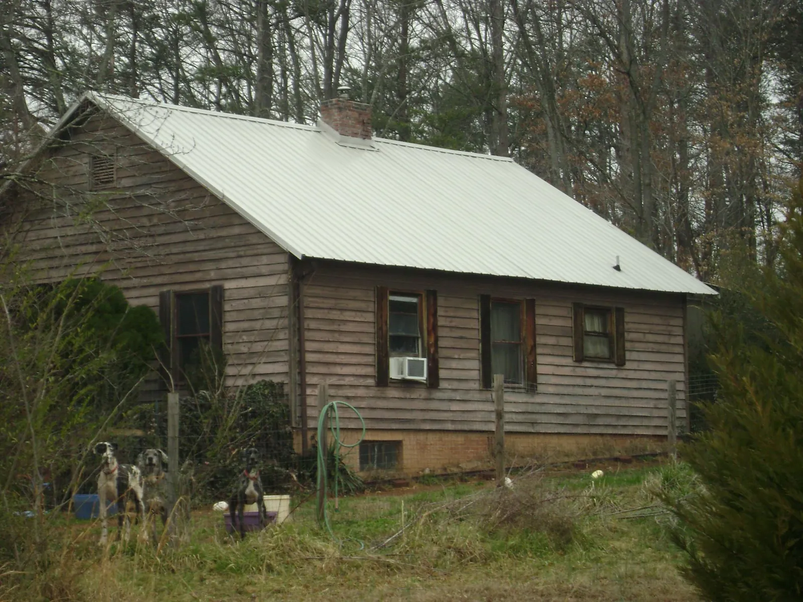 White metal roof on an old wood sided farmhouse, from a Metal Roof Installation job in Ricketts
